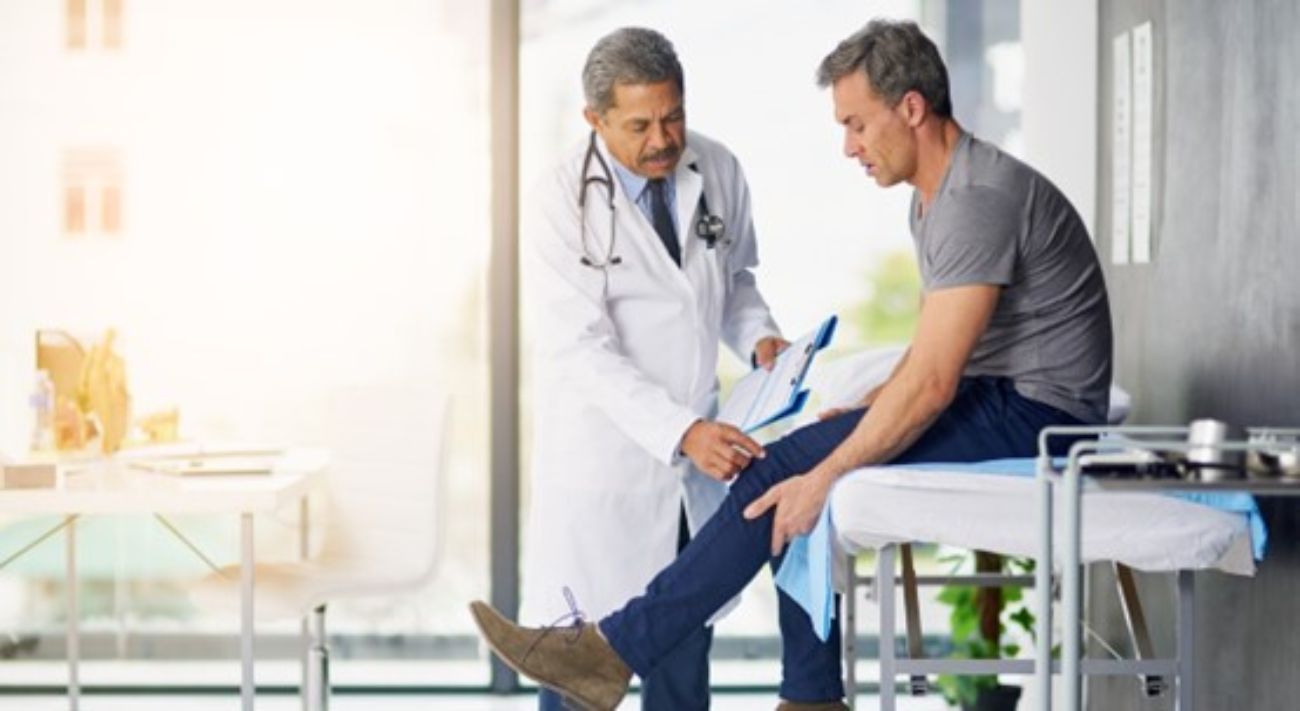 Man getting his knee examined by doctor
